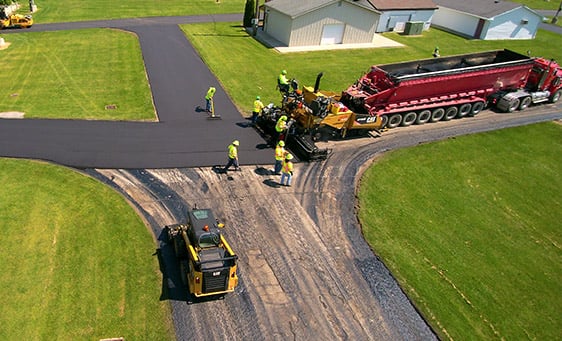 Overhead view of construction workers paving modified polymer on road