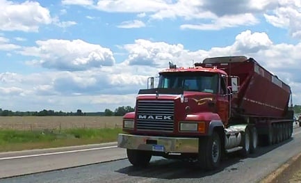 red construction truck driving on paved highway
